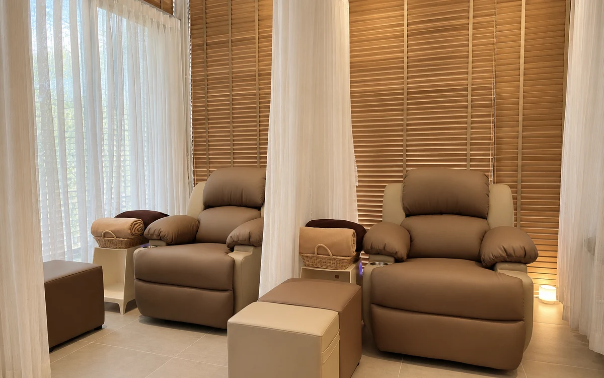 Empty reclining foot-massage chairs in a naturally lit relaxation area