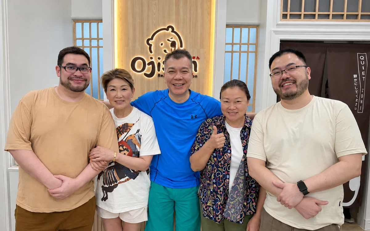 A group standing together in front of an Ojisan shop