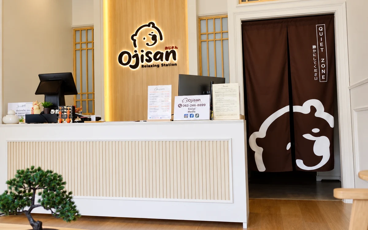 An Ojisan reception counter with the logo and curtains in a bright interior