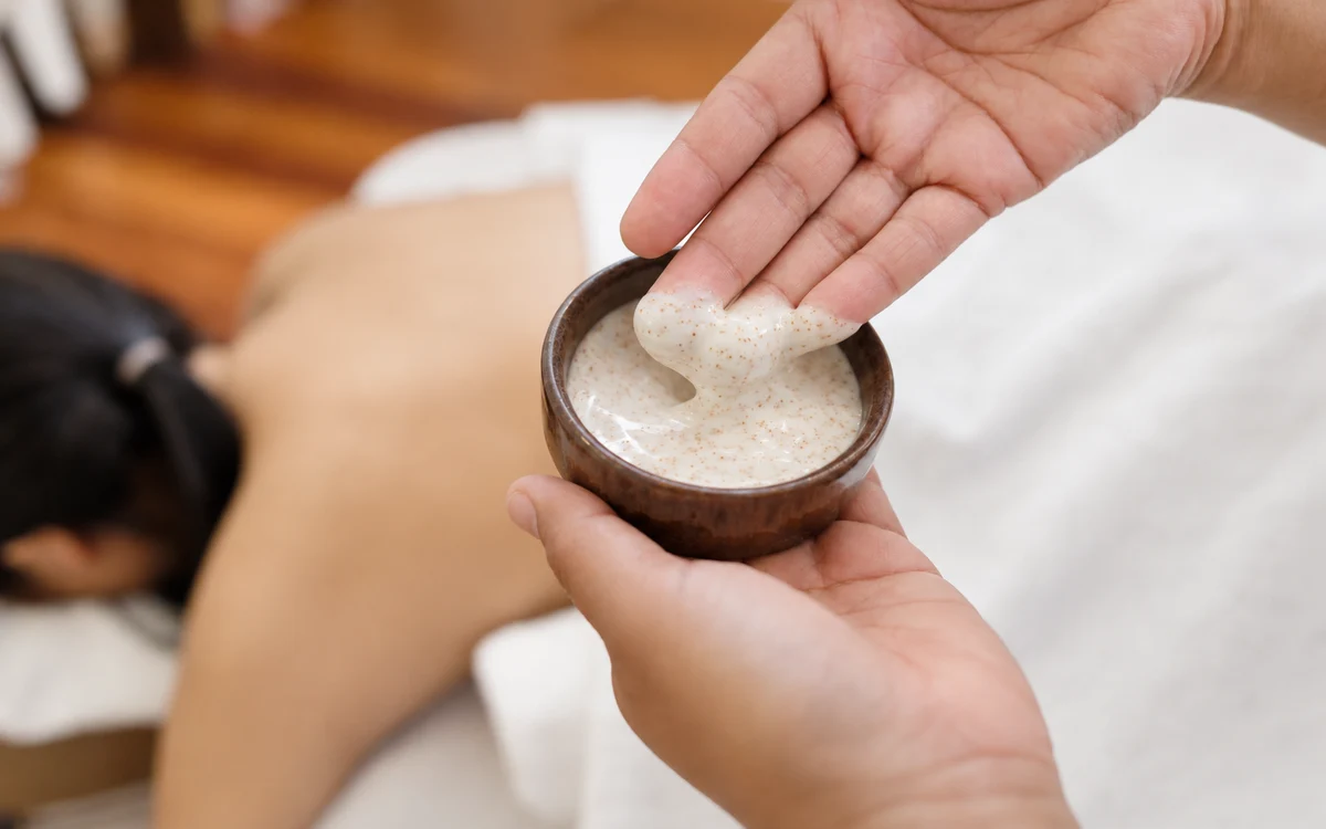 A close view of hands and a bowl of white scrub